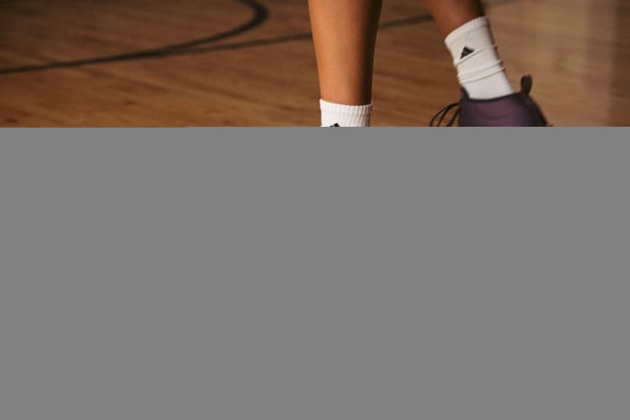 Side view of Candace Parker's purple and white adidas shoes.